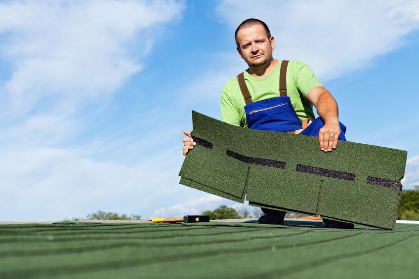 man installing roof shingles